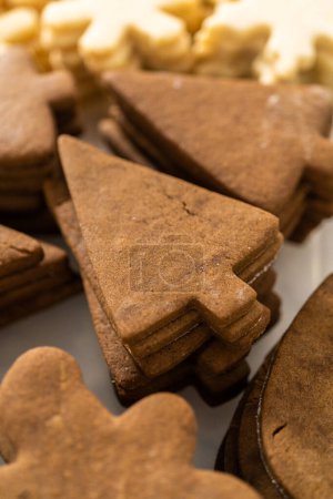 Téléchargez les photos : Des piles non décorées de biscuits au pain d'épice sont prêtes à être décorées de glaçage royal. - en image libre de droit