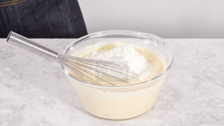 Photo for Step by step. Mixing ingredients in a glass mixing bowl to prepare coconut banana pancakes. - Royalty Free Image