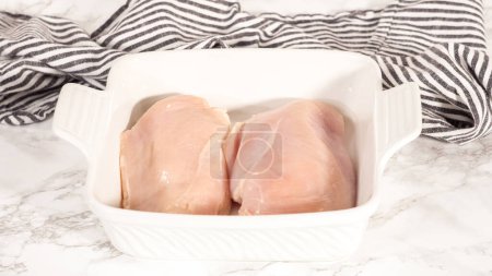 Photo for Step by step. Brushing raw chicken breast with vegetable oil. - Royalty Free Image