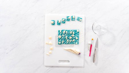 Photo for Flat lay. Dusting mini mermaid chocolate bars with editable glitter dust. - Royalty Free Image