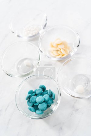 Foto de Ingredientes medidos en cuencos de vidrio para preparar mini barras de chocolate sirena. - Imagen libre de derechos