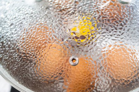 Foto de Huevos orgánicos marrones hirviendo en una olla para preparar huevos duros. - Imagen libre de derechos