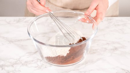 Photo for Step by step. Mixing ingredients in a glass mixing bowl to bake a chocolate cupcake. - Royalty Free Image