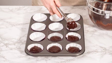 Photo for Step by step. Baking chocolate cupcakes. Scooping chocolate cupcake batter into a cupcake pan. - Royalty Free Image