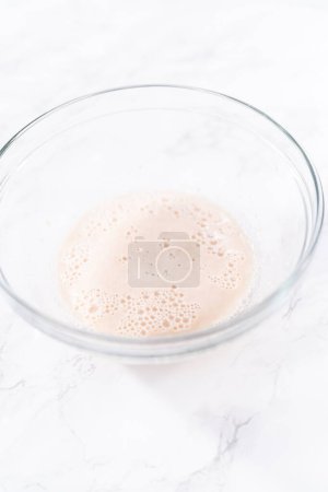 Photo for Activating an instant yeast in a glass mixing bowl. - Royalty Free Image