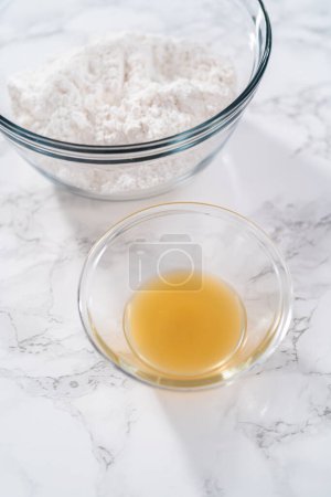 Photo for Lemon glaze. Measured ingredients in glass mixing bowls to prepare the lemon glaze. - Royalty Free Image