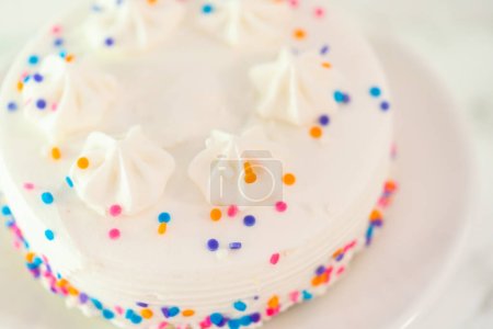 Photo for White little birthday cake with funfetti sprinkles on a white cake plate. - Royalty Free Image