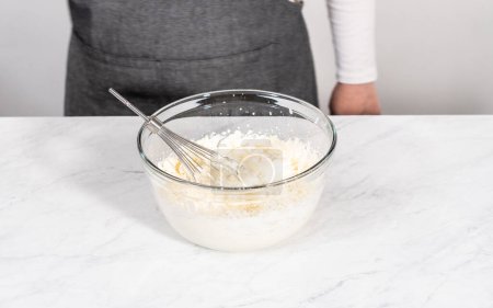 Photo for Mixing ingredients in a glass mixing bowl to prepare the homemade whipped cream. - Royalty Free Image