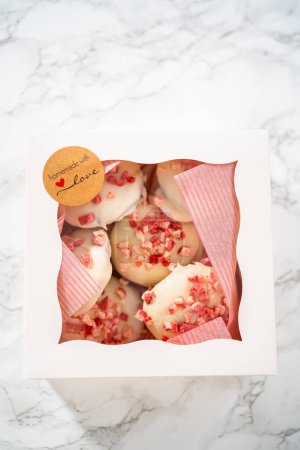 Téléchargez les photos : Emballage de biscuits au chocolat blanc à la menthe poivrée fraîchement cuits dans une boîte en papier blanc. - en image libre de droit
