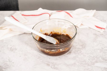 Téléchargez les photos : Chocolate cake dough in a glass mixing bowl on the counter. - en image libre de droit