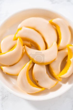 Téléchargez les photos : Biscuits au citron avec glaçage au citron. Biscuits au coin de citron fraîchement cuits avec glaçage au citron sur une assiette blanche. - en image libre de droit