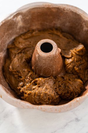 Photo for Filling metal bundt cake pan with cake butter to bake gingerbread bundt cake with caramel filling. - Royalty Free Image