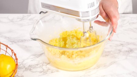 Téléchargez les photos : Pas à pas. Mélanger les ingrédients dans un bol à mélanger en verre pour préparer le gâteau au citron. - en image libre de droit