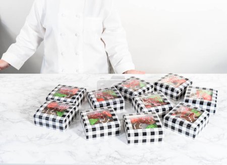 Foto de Embalaje de una variedad casera de galletas de caramelo y pan de jengibre para regalos de comida navideña en cajas de papel. - Imagen libre de derechos