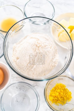 Photo for Lemon Cookies with White Chocolate. Measured ingredients in glass mixing bowls to bake lemon cookies with white chocolate. - Royalty Free Image