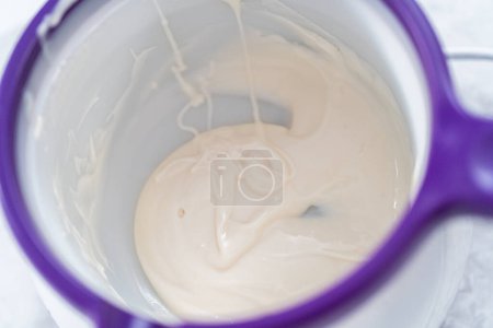 Photo for Melting color chocolate chips in electric candy melting pot. - Royalty Free Image