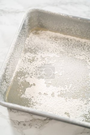 Téléchargez les photos : Graissage plaque de cuisson carrée en métal pour cuire des bonbons. - en image libre de droit