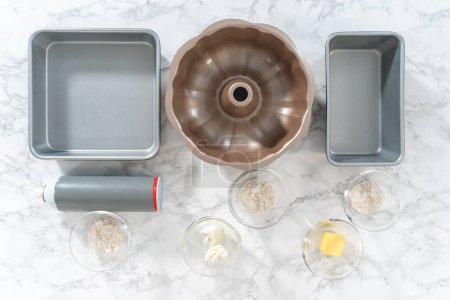 Téléchargez les photos : Pose plate. Ingrédients mesurés dans un bol en verre mélangé à un plat à pâtisserie graissé pour la cuisson. - en image libre de droit