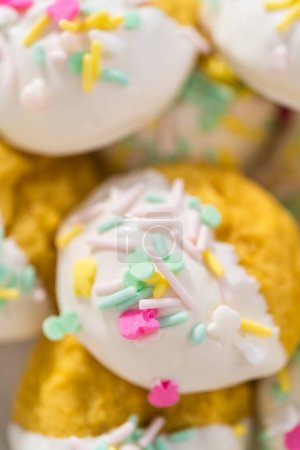 Photo for Lemon Cookies with White Chocolate. Freshly baked lemon cookies with white chocolate and decorated with Easter sprinkles on a white ceramic plate. - Royalty Free Image