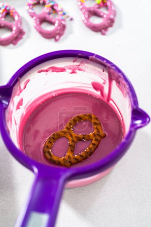 Téléchargez les photos : Dipping pretzels twists into melted chocolate to make mermaid pretzel twists. - en image libre de droit