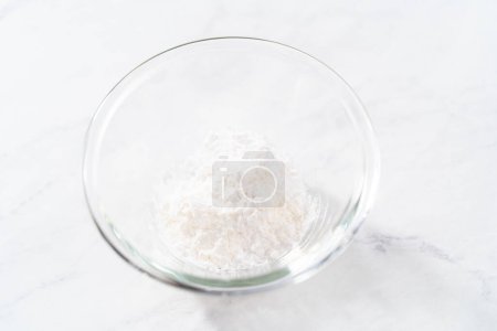 Téléchargez les photos : Mélanger les ingrédients avec un fouet à la main pour préparer la poussière de sucre en poudre. - en image libre de droit