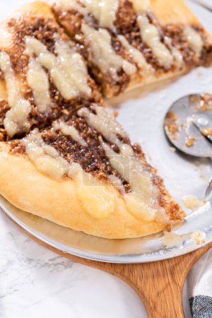 Photo for Freshly baked cinnamon dessert pizza with cream cheese drizzle. - Royalty Free Image