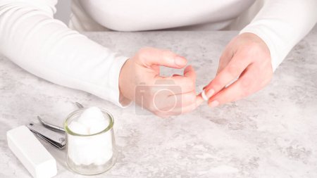 Photo for Woman finishing her manicure at home with simple manicure tools. Removing old nail polish from the nails. - Royalty Free Image