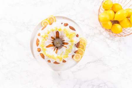 Photo for Flat lay. Lemon bundt cake decorated with lemon zest on a cake stand. - Royalty Free Image