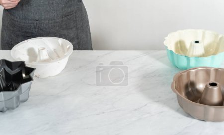 Téléchargez les photos : Différentes couleurs et formes de casseroles à gâteau bundt sur le comptoir de la cuisine. - en image libre de droit