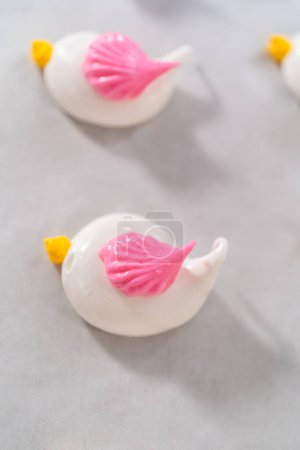 Photo for Piping meringue with piping bags into the baking sheet lined with parchment paper to bake Easter meringue cookies. - Royalty Free Image