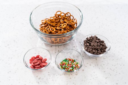 Foto de Ingredientes medidos en cuencos de vidrio para hacer una corona de Navidad de pretzel de chocolate. - Imagen libre de derechos