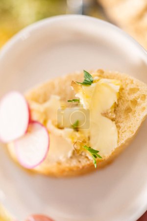 Téléchargez les photos : Trancher la baguette française avec du beurre aromatisé et du radis. - en image libre de droit