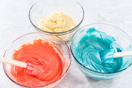 Foto de Mezcla de colorante de alimentos rojos y azules en la masa de pastel. - Imagen libre de derechos