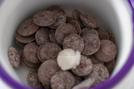 Téléchargez les photos : La fusion du chocolat fond dans un melting pot de bonbons pour préparer des mini chocolats gourmands avec des saupoudres. - en image libre de droit