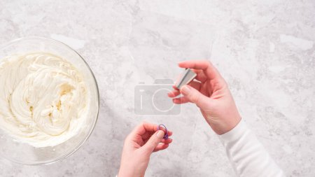 Téléchargez les photos : Pose plate. Pas à pas. Glaçage blanc crème au beurre dans un sac de tuyauterie avec une pointe en métal. - en image libre de droit