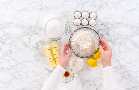 Téléchargez les photos : Pose plate. Ingrédients dans des bols à mélanger en verre pour préparer le gâteau au citron. - en image libre de droit