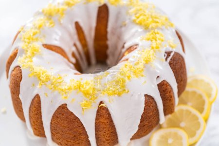 Téléchargez les photos : Gâteau lapin au citron décoré de zeste de citron sur un stand de gâteau. - en image libre de droit