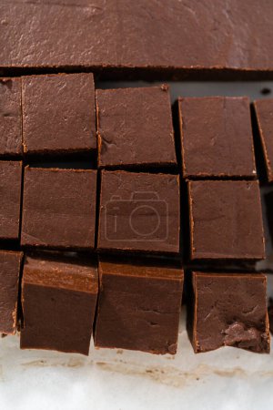 Téléchargez les photos : Couper du caramel maison en petits morceaux sur une planche à découper blanche. - en image libre de droit