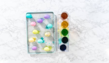 Foto de Acostado. Huevo de Pascua para colorear. Tinte huevos orgánicos blancos en diferentes colores para Pascua. - Imagen libre de derechos