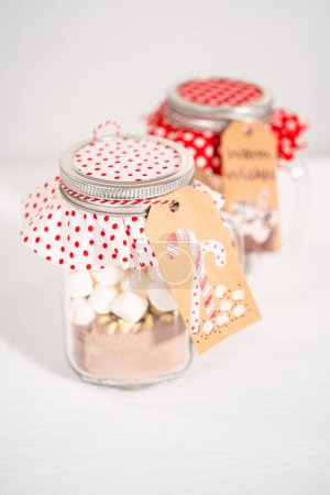 Photo for Making homemade hot chocolate mix in drinking mason jar for Christmas food gift. - Royalty Free Image