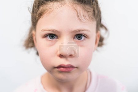 Téléchargez les photos : Petite fille avec des bretelles arc-en-ciel souriant à la caméra. - en image libre de droit