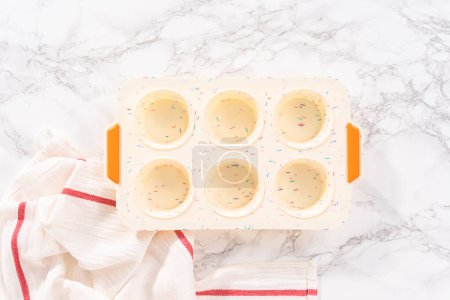 Téléchargez les photos : Pose plate. Remplir le moule à muffins en silicone avec des ingrédients pour cuire le bacon et le muffin aux œufs au fromage. - en image libre de droit