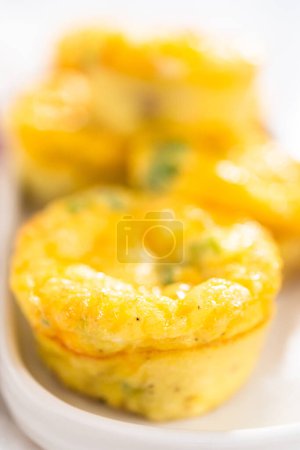 Photo for Bacon and cheese egg muffin on a white serving plate. - Royalty Free Image