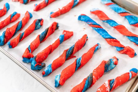 Photo for Rising patriotic cinnamon twists on the baking sheet lined with parchment paper. - Royalty Free Image