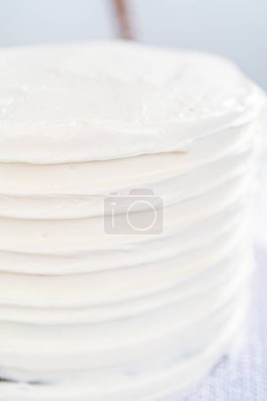 Photo for Frosting chocolate cake with vanilla buttercream frosting. - Royalty Free Image