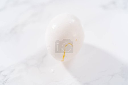 Téléchargez les photos : Éplucher les œufs durs au comptoir de la cuisine en marbre. - en image libre de droit