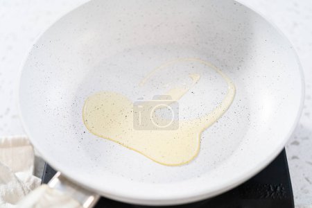 Photo for Frying eggs on a nonstick frying pan to make breakfast egg and sprout sandwich. - Royalty Free Image