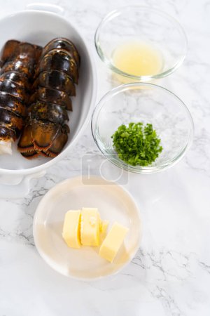 Foto de Acostado. Ingredientes medidos en cuencos de vidrio para preparar colas de langosta de ajo. - Imagen libre de derechos