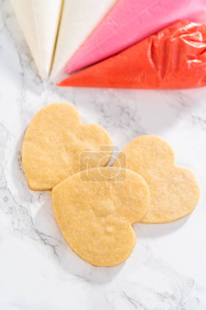 Foto de Gelatina real casera en bolsas de tuberías listas para decorar galletas de azúcar en el mostrador de la cocina. - Imagen libre de derechos