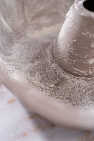 Photo for Greasing bunt cake pan to bake apple bundt cake with caramel glaze. - Royalty Free Image